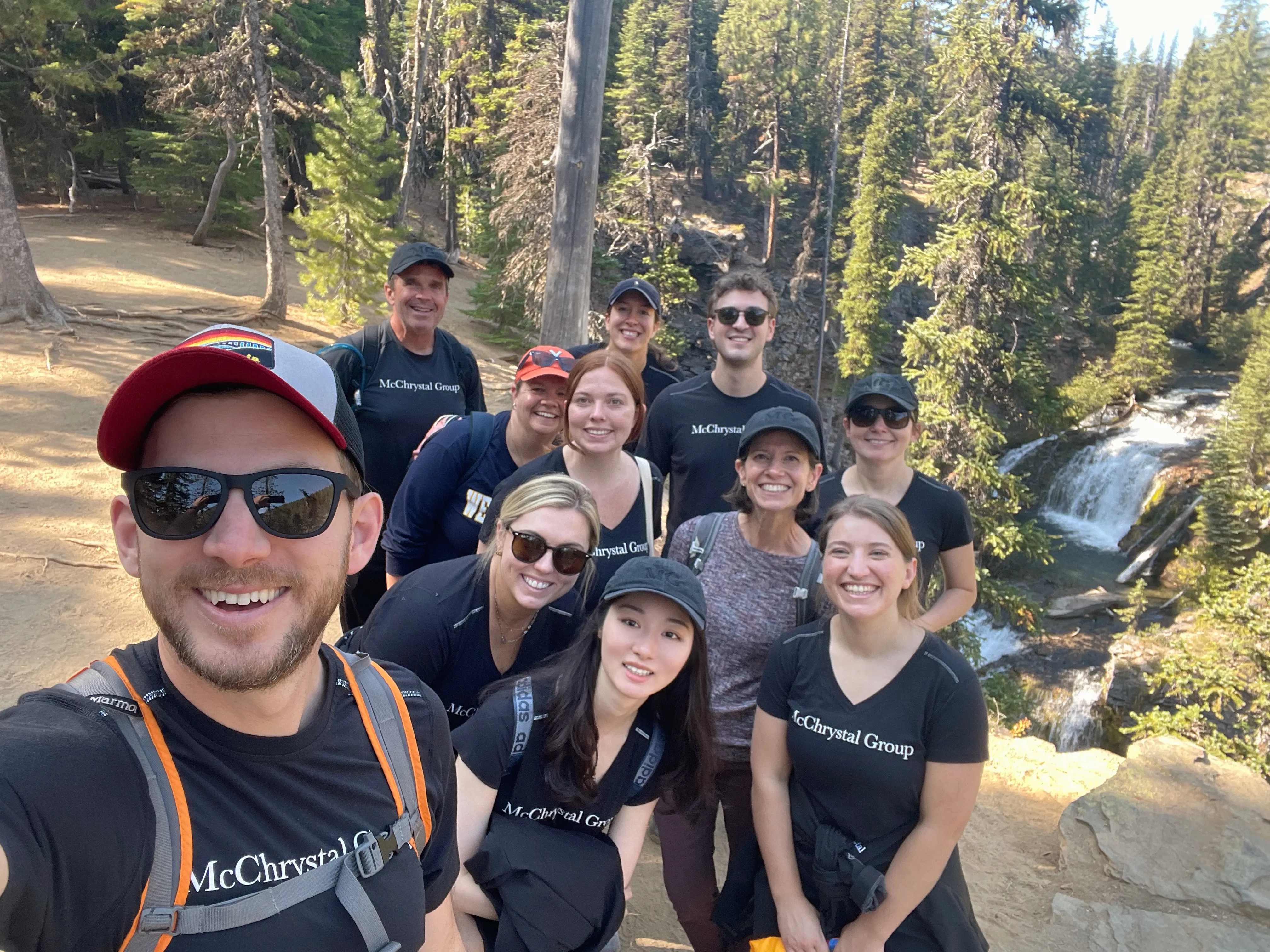 Liz hiking beside a waterfall with former colleagues